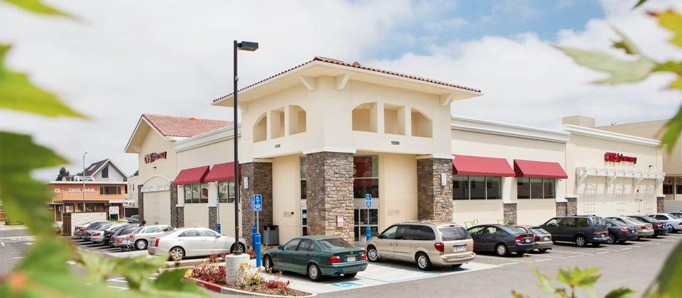 A Large Retail Store with Several Cars Parked in Front