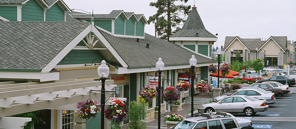A Lively Street Lined with Parked Vehicles in Front of Diverse Shops