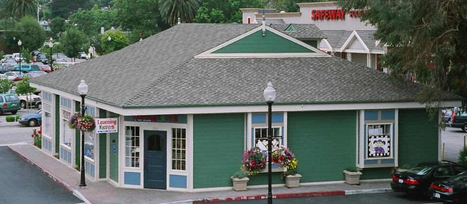 A Small Green Building Featuring a Blue Roof