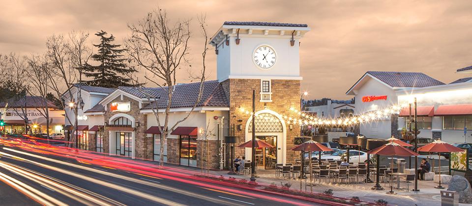 A Scenic View of a Street Adorned with a Clock Tower and a Welcoming Restaurant